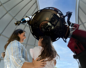 Mother and daughter looking through the telescope in the observatory at Tellus Science Museum
